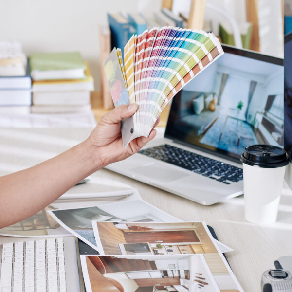 Interior designer choosing color palette for new project and looking at printed photos of rooms